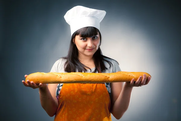 Woman cook holding fresh baked bread — Stock Photo, Image