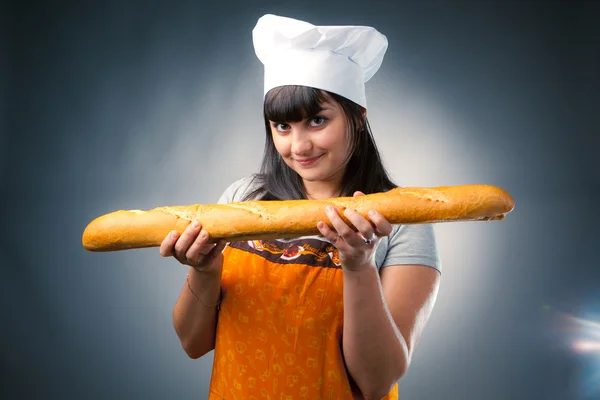 Cocinera sosteniendo pan francés — Foto de Stock