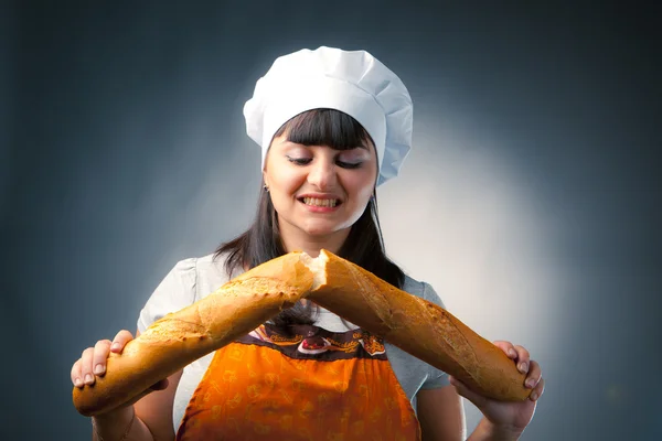 Woman cook breaking a french bread — Stock Photo, Image