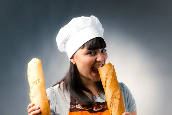 Woman cook tasting a french bread — Stock Photo, Image