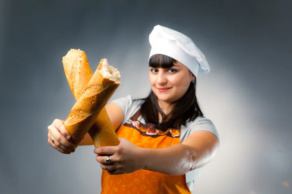 Žena vařit přes francouzský chléb, zaměření na chleba — Stock fotografie
