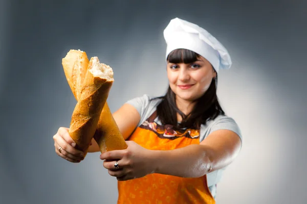 Kadın aşçı Fransız ekmeği, ekmek odak geçiş — Stok fotoğraf