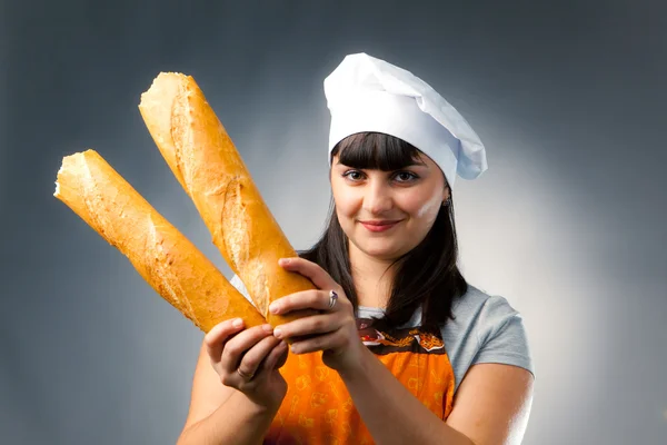 Woman cook holding breaked french bread — Stock Photo, Image