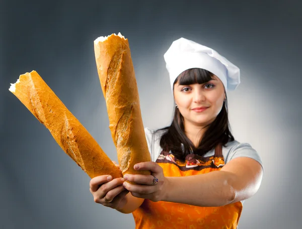 Woman cook holding broken french bread, focus on the bread — Stock Photo, Image