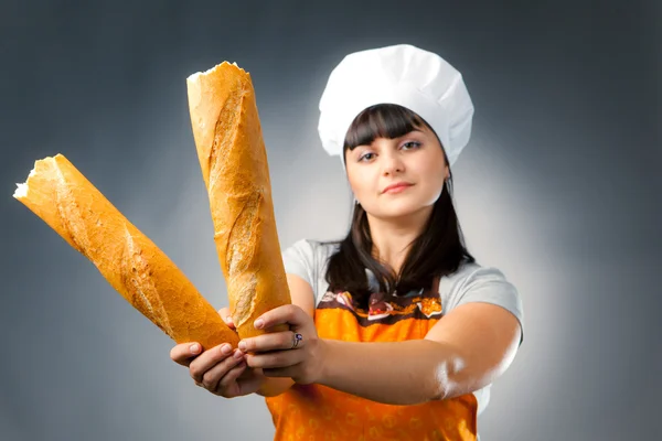 Woman cook holding french bread, focus on the bread — Stock Photo, Image
