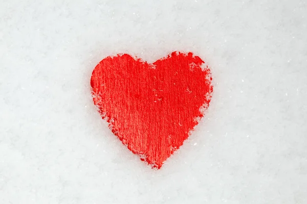 Красное сердце на снегу — стоковое фото
