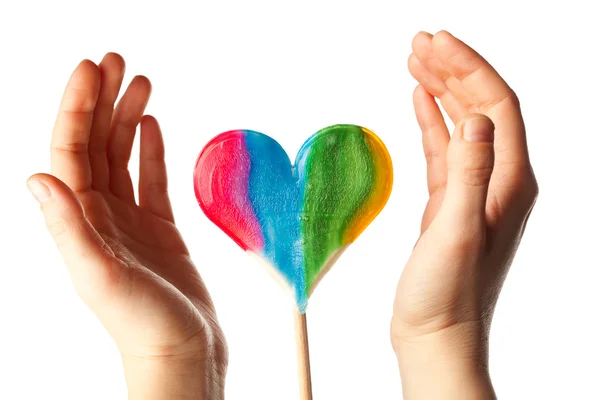 Händer kring lollipop hjärta — Stockfoto
