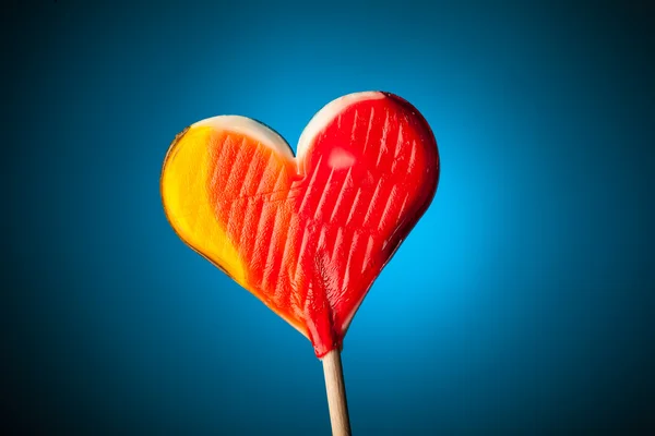 Lollipop hjärtat på blå bakgrund — Stockfoto