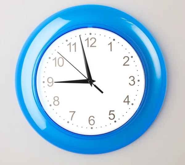 Reloj de oficina azul en la pared gris —  Fotos de Stock