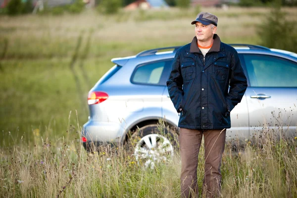 Adult man and car as the background — Stock Photo, Image