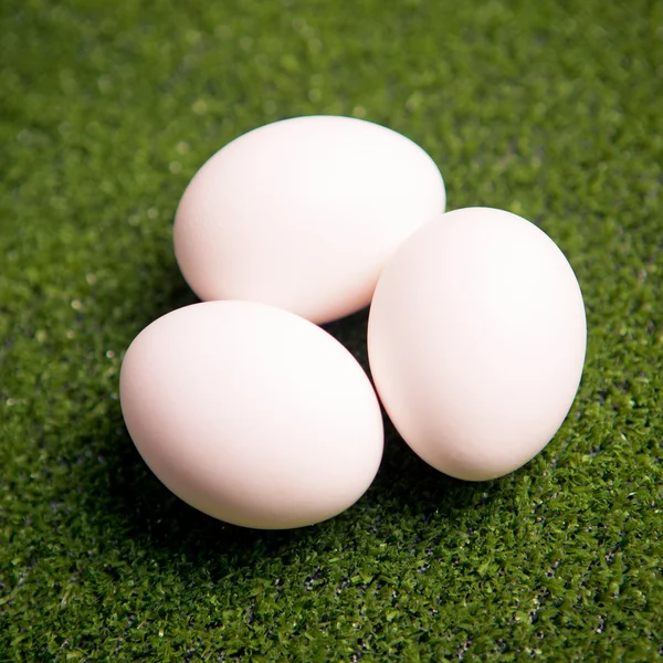 Skupina vajec na zeleném trávníku — Stock fotografie