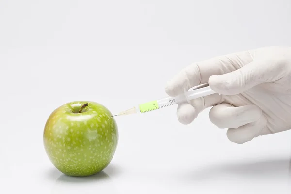 Injection d'un liquide dans une pomme . — Photo