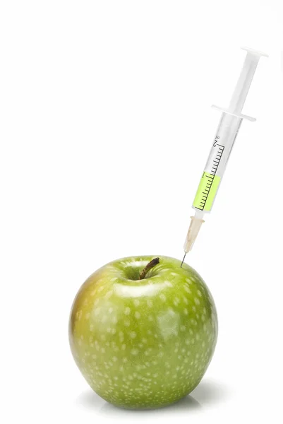Syringe inserted in an apple. — Stock Photo, Image
