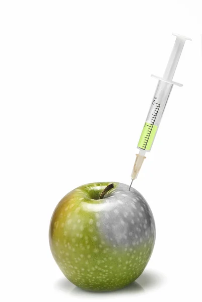 Syringe inserted in an apple. — Stock Photo, Image