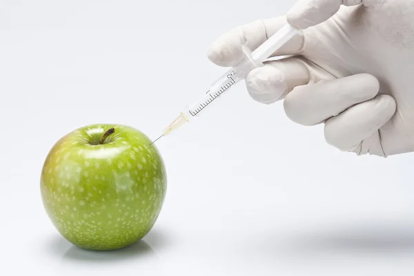 Injecting a fluid into an apple. — Stock Photo, Image