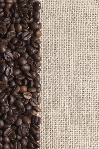 Säckväv bakgrund med kaffebönor. — Stockfoto