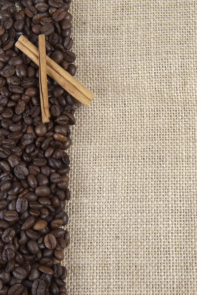 Kaffebönor och kanel på en säckväv. — Stockfoto