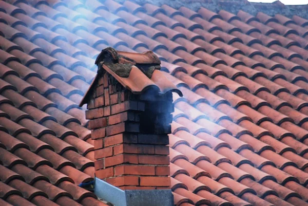 Chimney on a roof with smoke — Stock Photo, Image