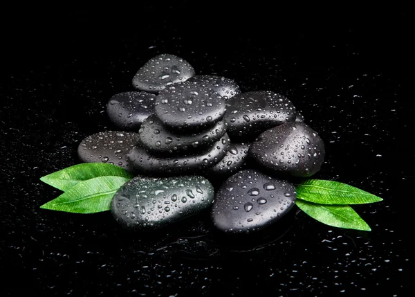 Piedras de spa blak con hojas y gotas de agua . — Foto de Stock