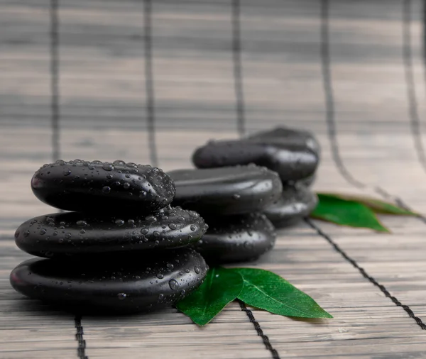 Black stone with leaf. massage stones — Stock Photo, Image