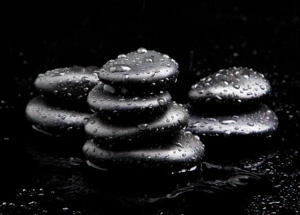 Pietre termali. nero lucido zen pietre con gocce d'acqua su b nero — Foto Stock