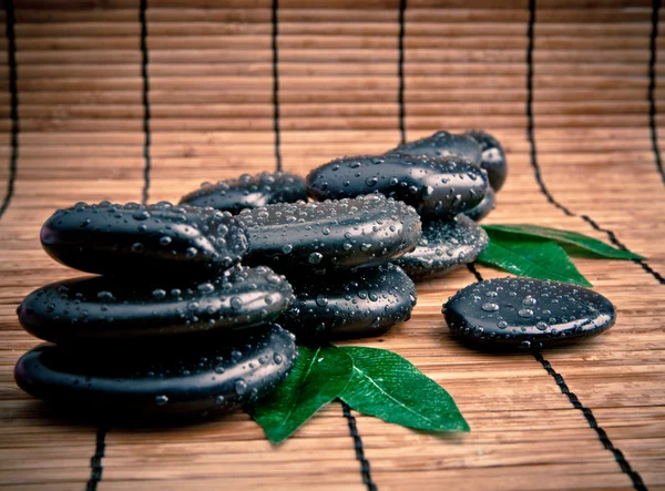 Blak spa stones with leaf and water drops. — Stock Photo, Image