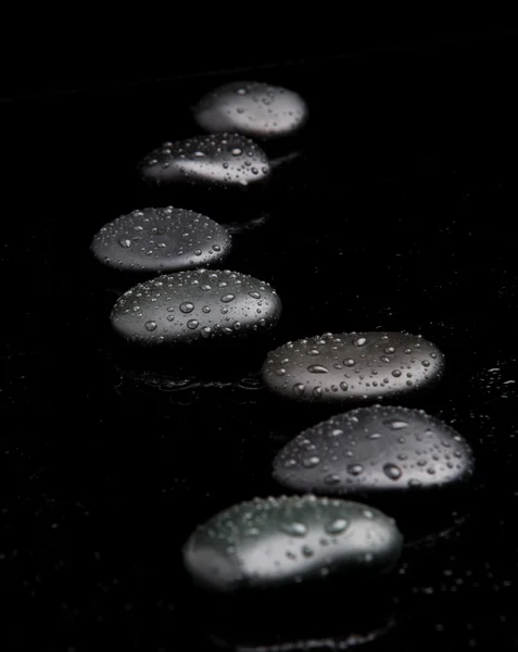 Spa Stones. pedras zen brilhantes pretas com gotas de água sobre b preto — Fotografia de Stock