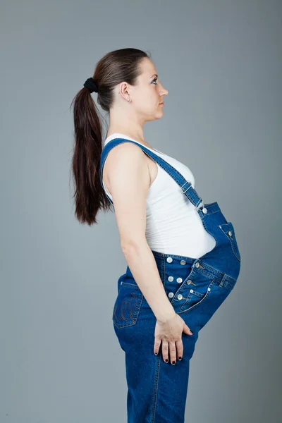 Πορτρέτο του έγκυος γυναίκα μελαχρινή σε γκρι φόντο. — Φωτογραφία Αρχείου