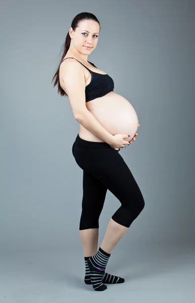 회색 배경에 임신 갈색 머리 여자의 초상화. — 스톡 사진