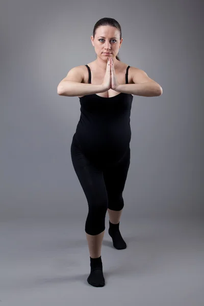 임신한 여자 회색 배경에 체조 연습을 하 고. — 스톡 사진