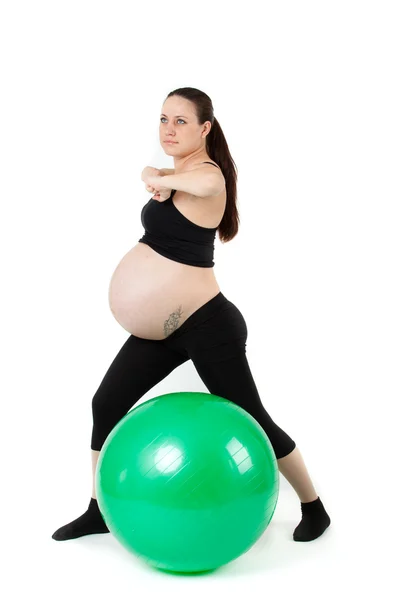 Piękna kobieta w ciąży z ćwiczeń, które bal. na tle — Zdjęcie stockowe
