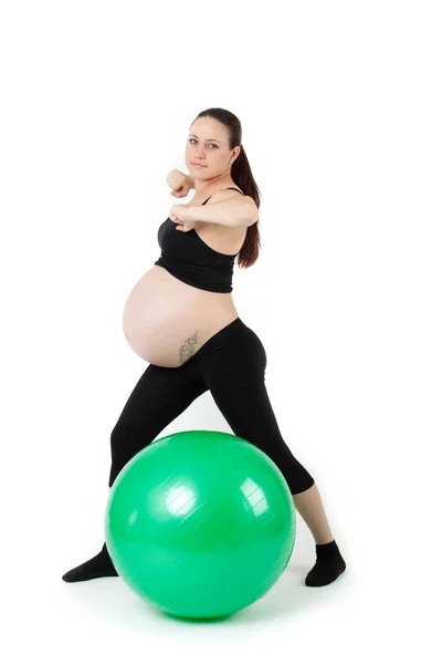 Piękna kobieta w ciąży z ćwiczeń, które bal. na tle — Zdjęcie stockowe