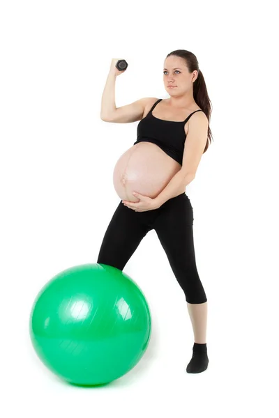 Schöne schwangere Frau sitzt mit Übung bal. isoliert auf — Stockfoto