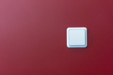 Plastic light switch in the red wall clipart