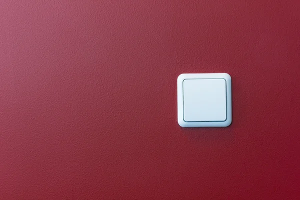 Пластиковий вимикач світла в червоній стіні — стокове фото