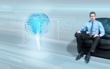 Young handsome businessman sitting on the sofa analyzing data from virtual holographic interface screen. clipart