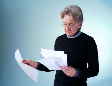 Senior man reading important papers. Attractive seniors lifestyle in studio uniform background series. clipart