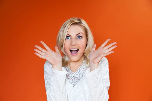 Surprised sexy blonde! Lady against orange background wearing fashionable dress studio shot — Stock Photo, Image