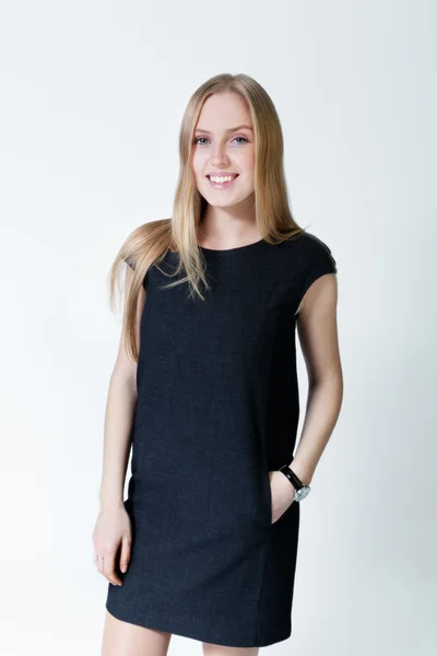 Happy smiling blonde wearing fashionable dress. Fresh new young face. Studio shot, uniform background — Stock Photo, Image