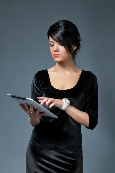 Σέξι μελαχρινή μοντέλο χρησιμοποιώντας τη νέα συσκευή μαξιλάρι αφής. ένα από τη συλλογή. — Φωτογραφία Αρχείου