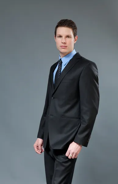 Young businessman wearing classic dark suit. Half-turn studio shot. One of a series. — Stock Photo, Image