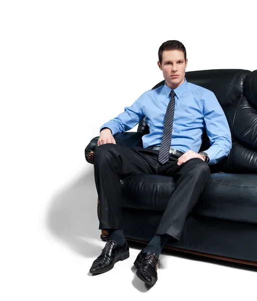 Młody atrakcyjny biznesmen apodyktyczny, siedząc na kanapie. — Zdjęcie stockowe