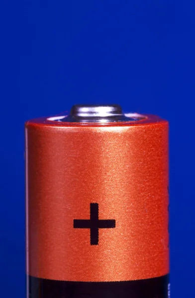 Baterie plus na modrém pozadí — Stock fotografie