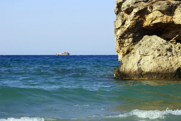 Segelbåt och rock på kusten — Stockfoto