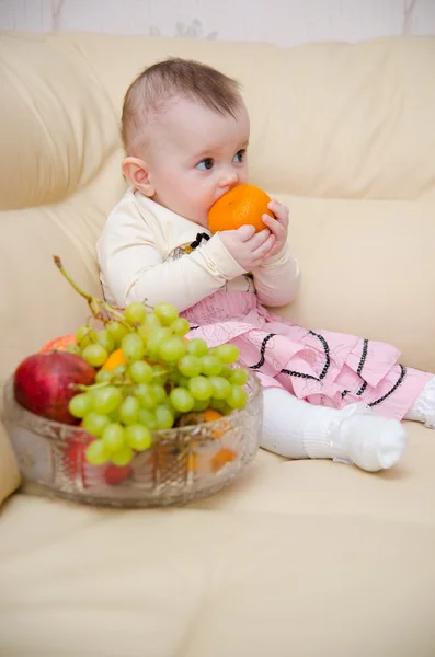 Kleines Mädchen isst Früchte lizenzfreie Stockbilder