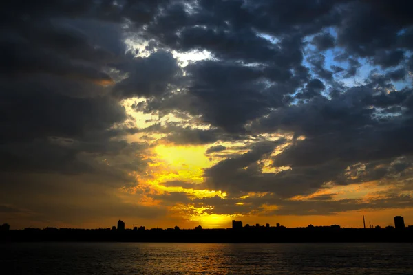 日落在河上的城市 免版税图库照片