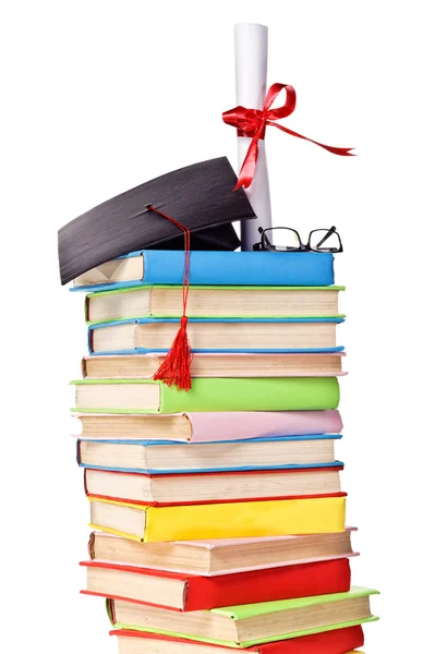 Cap and diploma on top of stack of books — Stock Photo, Image