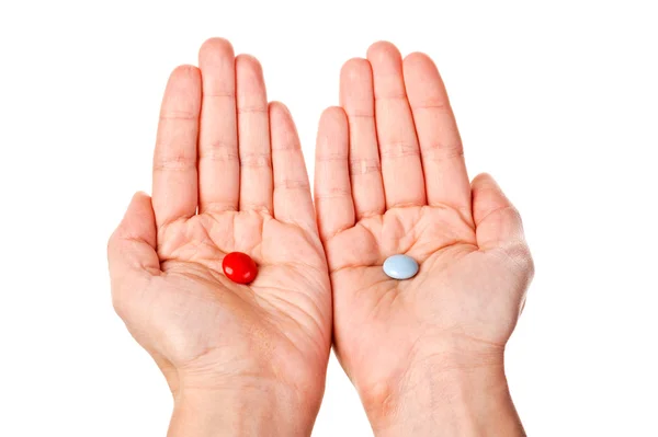 Pílulas vermelhas e azuis em mãos de mulher — Fotografia de Stock