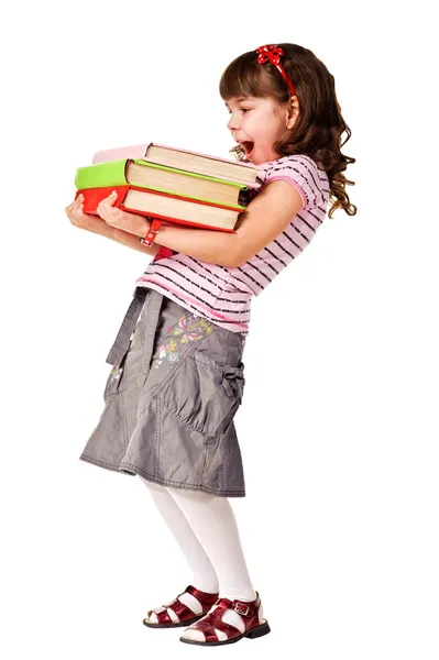Счастливая маленькая школьница с грудой тяжелых книг — стоковое фото