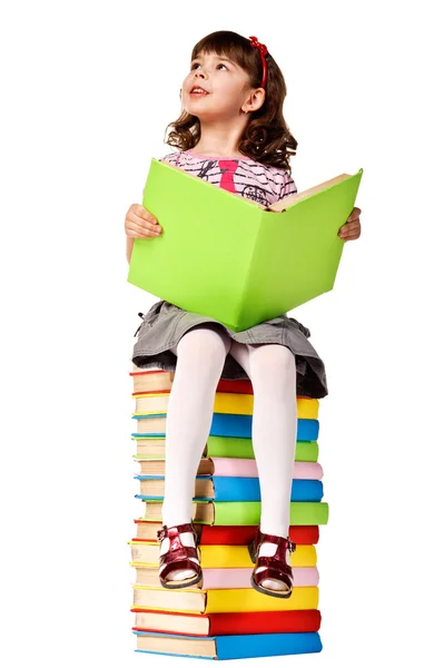 Meisje, zittend op stapel boeken. — Stockfoto